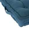 A close-up view of a teal floor cushion, showing its tufted texture and side handles. Náhled obrázku produktu