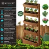 A vertical planter with multiple tiers, filled with plants, set against a wooden fence and green foliage. A robin is perched on a fence post. Produktbild-Vorschau