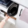 A hand is reaching into a cabinet to take out a stack of oval serving platters. Produktbild-Vorschau