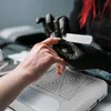 A close-up of a person getting their nails done. Anteprima dell’immagine prodotto