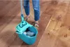 A person is mopping a wooden floor with a bucket and mop. Produktbild-Vorschau