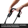 Hands holding the handle of a piece of garden equipment, with a safety switch visible. Produktbild-Vorschau