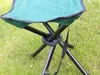 A close-up view of a green folding stool with black metal legs, set on grass. Voir les images du produit
