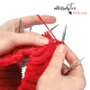 Hands knitting with red yarn and knitting needles. Produktbild-Vorschau