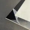 A close-up shot of a black sheet with a protective film being peeled back, resting on a textured gray surface. Podgląd zdjęcia produktu