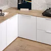 A corner of a modern room with white cabinets and a wooden countertop. Náhled obrázku produktu