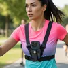 A woman is running outdoors with a phone harness attached to her chest. Náhľad obrázku produktu