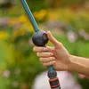 A hand holding a garden hose with a control mechanism. Voir les images du produit
