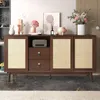 A wooden sideboard with rattan woven doors and drawers, decorated with various items on top. Produktbild-Vorschau