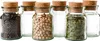 A set of six small glass jars with cork stoppers, some filled with spices or grains. Produktbild-Vorschau