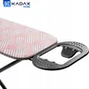 A close-up view of an ironing board with a pink and white patterned cover and a gray metal iron rest attachment. Produktbild-Vorschau