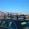 A car with a ski rack loaded with skis and snowboards parked in a mountainous, snowy landscape. Podgląd zdjęcia produktu
