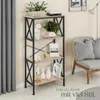 A tall, narrow bookshelf with four shelves, decorated with various items, placed in a room next to a grey armchair and a grey curtain. Náhled obrázku produktu