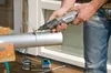 A person is using a Dremel tool to cut a metal pipe. Anteprima dell’immagine prodotto