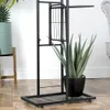 A black metal plant stand with multiple tiers, holding a large potted aloe vera plant. Another potted plant is partially visible to the left. Náhled obrázku produktu