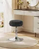 A black stool with a silver base is placed on a light beige rug in front of a white and dark gray vanity with a mirror. Náhled obrázku produktu