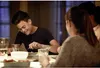 A group of people are sitting at a table, eating a meal. Anteprima dell’immagine prodotto