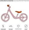 A pink balance bike with a brown seat and handlebars, shown against a white background. Icons and text describing features are present at the bottom. Náhľad obrázku produktu