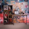 A desk and bookshelf set against a graffiti-style brick wall. Náhľad obrázku produktu