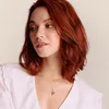 A woman wearing a white shirt and a necklace with a pendant. Produktbild-Vorschau
