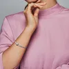A close-up shot of a woman's arm wearing a silver bracelet. Podgląd zdjęcia produktu