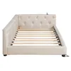 A beige upholstered daybed frame with a tufted headboard and wooden slats for mattress support, shown from a side angle against a white background. Náhľad obrázku produktu