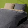A close-up view of a bed with beige and anthracite bedding. Produktbild-Vorschau