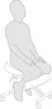 A person is sitting on a kneeling chair. Produktbild-Vorschau