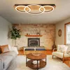 A living room with a fireplace, sofa, coffee table, and a modern ceiling light. Anteprima dell’immagine prodotto