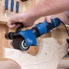 A person is using a blue and black sanding machine on a wooden object in a workshop setting. Produktbild-Vorschau
