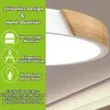 A close-up of a modern LED ceiling light with a wooden accent, set against a green informational panel. Voir les images du produit