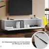 A white, high-gloss, wall-mounted TV cabinet with two open compartments, displaying books, controllers, and decorative items. A yellow arrow points to a close-up of the cabinet door hinge mechanism. Anteprima dell’immagine prodotto