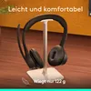 A black headset is displayed on a white stand against an orange and brown background. Produktbild-Vorschau