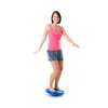A woman is balancing on a blue therapy disc. Produktbild-Vorschau