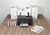 A black Canon PIXMA G4570 multifunction printer is shown on a wooden desk, surrounded by stacks of paper and four bottles of ink. Produktbild-Vorschau