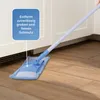 A blue and white mop head is shown on a wooden floor, cleaning near a white cabinet with a vent. A blue speech bubble with German text is overlaid on the image. Produktbild-Vorschau