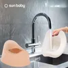 A baby potty and a potty trainer are shown in a sink area with a faucet running. Produktbild-Vorschau