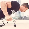 A man is doing push-ups outdoors with a modern building in the background. Náhľad obrázku produktu
