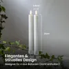 Two white LED candles with flickering flames are shown in a decorative setting with greenery. Podgląd zdjęcia produktu