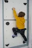 A young boy is climbing on an indoor climbing wall in a room. Anteprima dell’immagine prodotto