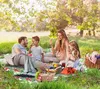 A family enjoying a picnic in a park under a tree. Náhled obrázku produktu