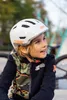 A young boy wearing a white helmet and a camouflage jacket. Produktbild-Vorschau