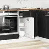 A close-up view of a modern black kitchen cabinet with an open door, revealing white shelves and dishes, next to a stainless steel oven. Produktbild-Vorschau