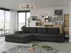 A modern living room with a large dark gray sectional sofa as the main focus, set against a backdrop of large windows and decorative wall elements. Náhľad obrázku produktu