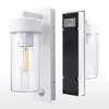 A white outdoor wall light with a clear glass cylinder and a motion sensor is shown against a light gray and white background. Produktbild-Vorschau