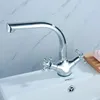 A chrome faucet is installed on a white sink, with a marble-patterned wall in the background. Náhled obrázku produktu
