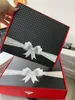 Two gift boxes are stacked on top of each other, with a hand holding the top box. Produktbild-Vorschau