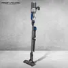 A cordless vacuum cleaner is displayed standing upright against a textured gray wall. Náhled obrázku produktu