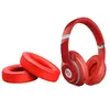 A pair of red headphones and two red ear pads are displayed against a white background. Produktbild-Vorschau