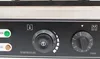 Close-up of a black appliance control panel with temperature and timer knobs. Produktbild-Vorschau